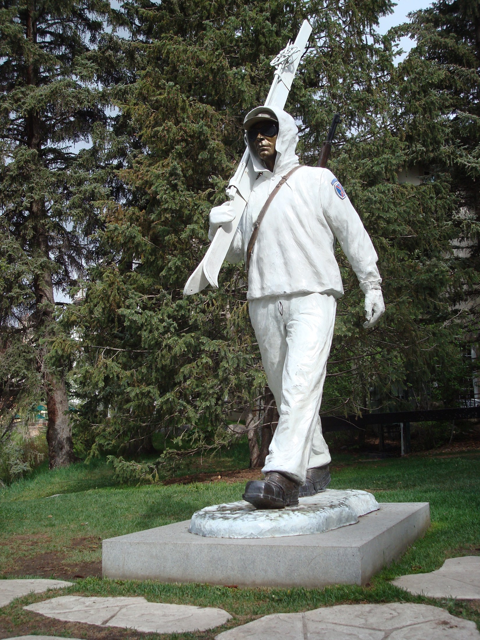 La estatua conmemorativa de la 10.ª División de Montaña en Slifer Plaza, Vail: un soldado esquiador de bronce con traje blanco de combate invernal, esquís al hombro y un rifle a la espalda